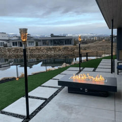 The Outdoor Plus Newport Fire Table with Yellow Flames in Outside View