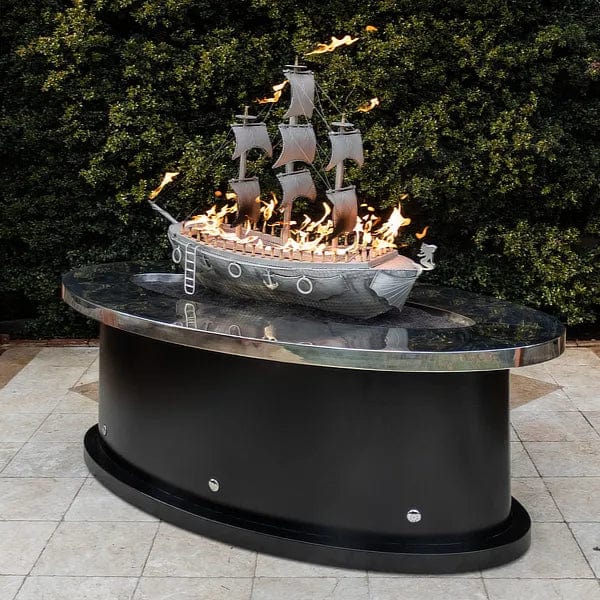 The Outdoor Plus 72-inch La Pinta Fire Table Stainless on Top with grass behind