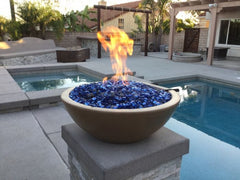 The Outdoor Plus Sedona GFRC Fire and Water Bowl With Stone Media and Yellow Flame in Pool Area