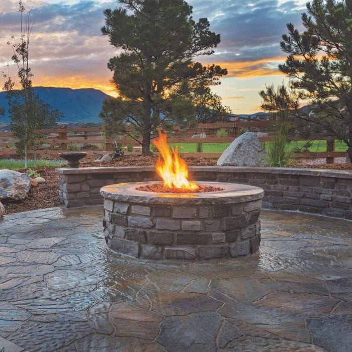 Warming Trends Crossfire Circular Tree-Style Brass Gas Fire Pit wit background Stone Table